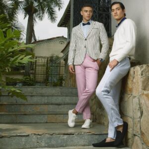 Two stylish young men posing in fashionable attire in an outdoor setting in Colombia.