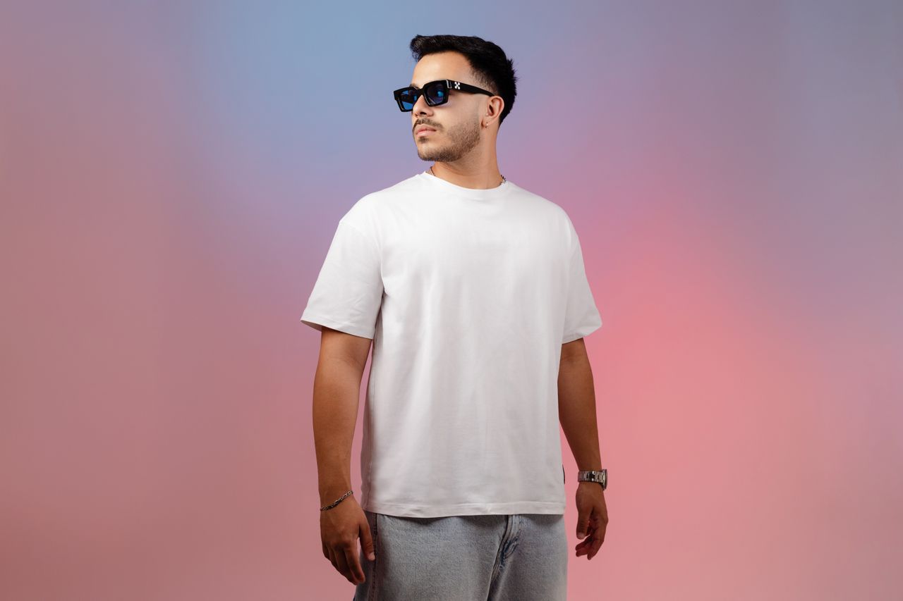 Casual portrait of a confident man in a white t-shirt with a gradient backdrop.